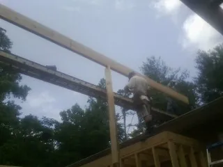 Carpenter setting a ridge beam over a new addition frame — Ice Dam Removal by Roofing Brothers in West Milford