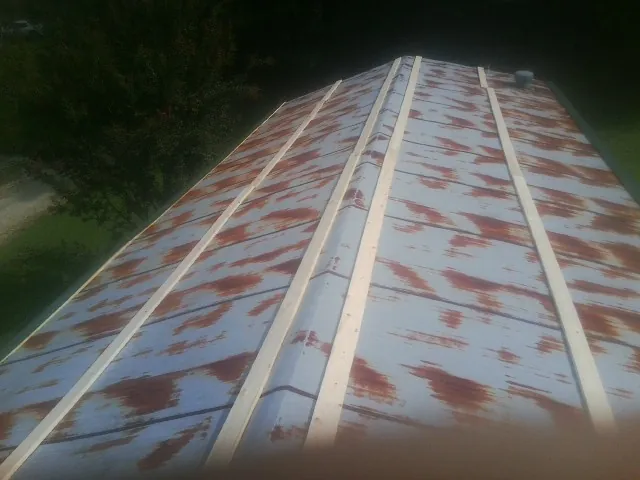 Rusted metal roof panels with new wood purlins before replacement — Storm Damage Roof Repair in West Milford by Roofing Brothers