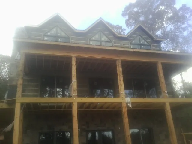 Dormers and porch framing on a large log home under construction — Roof Coating work by our crew in West Milford