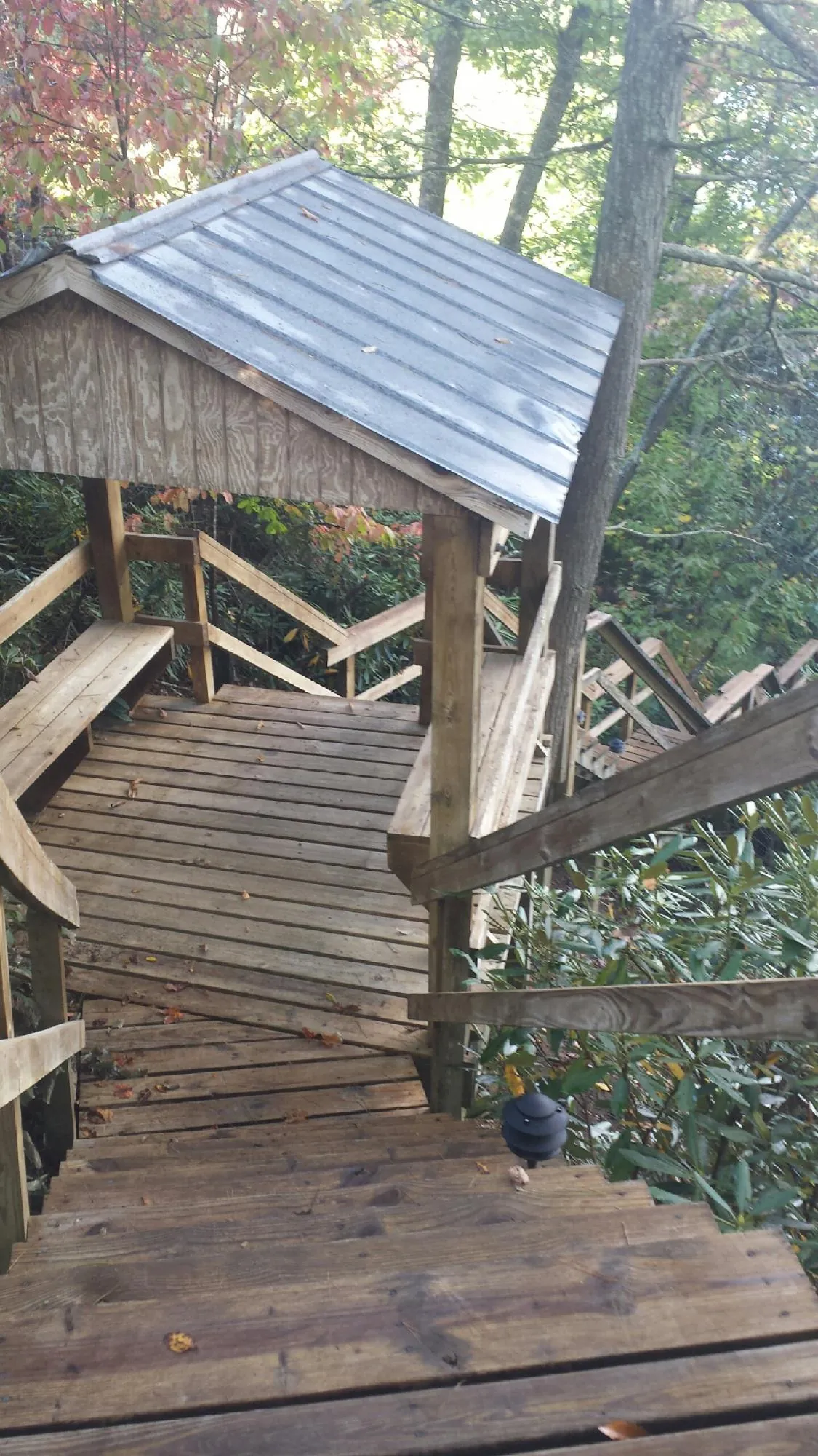 Metal roofed shelter over wooden steps on a wooded walkway — Skylight Repair & Installation work by our crew in West Milford